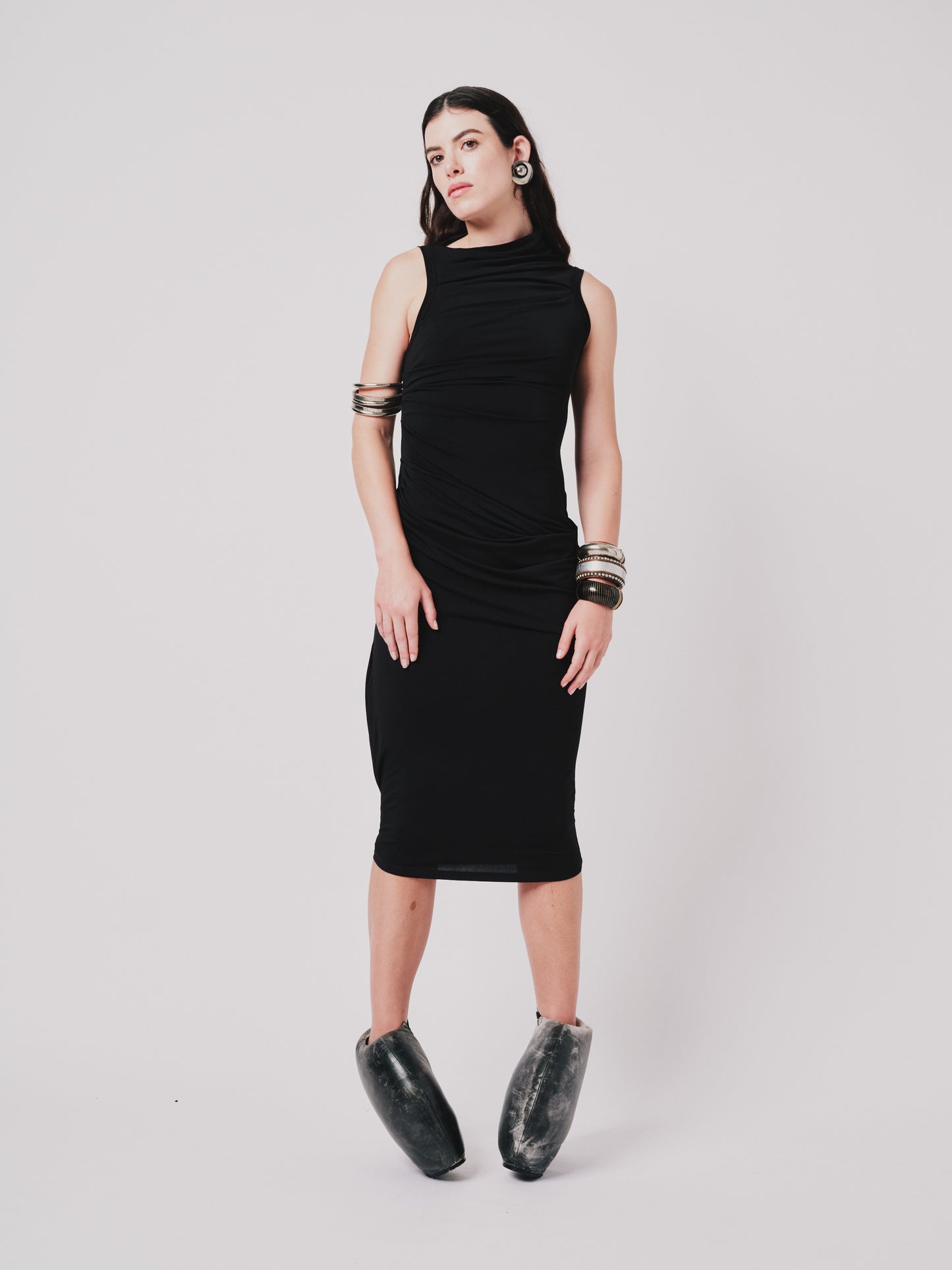 Woman wearing a black Paloma sleeveless dress with a plain background