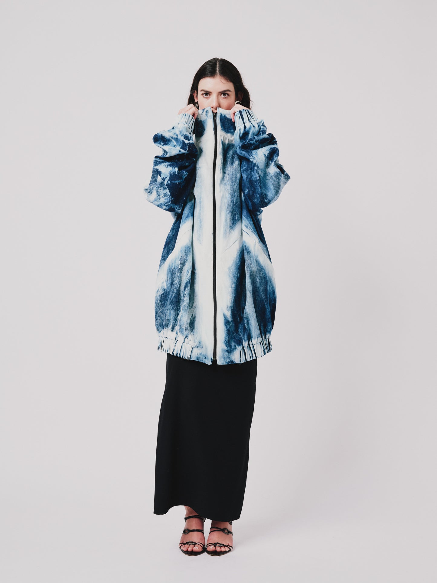 Person wearing a distressed youhan jacket and black skirt on a white background. Front view