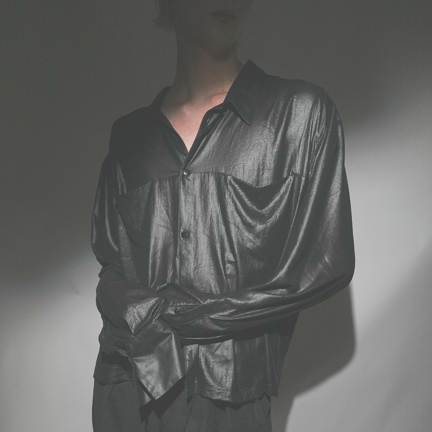 Close-up shot of the Marq Shirt in Liquid Black detailing the drape, inseam pocket detail, and button closure