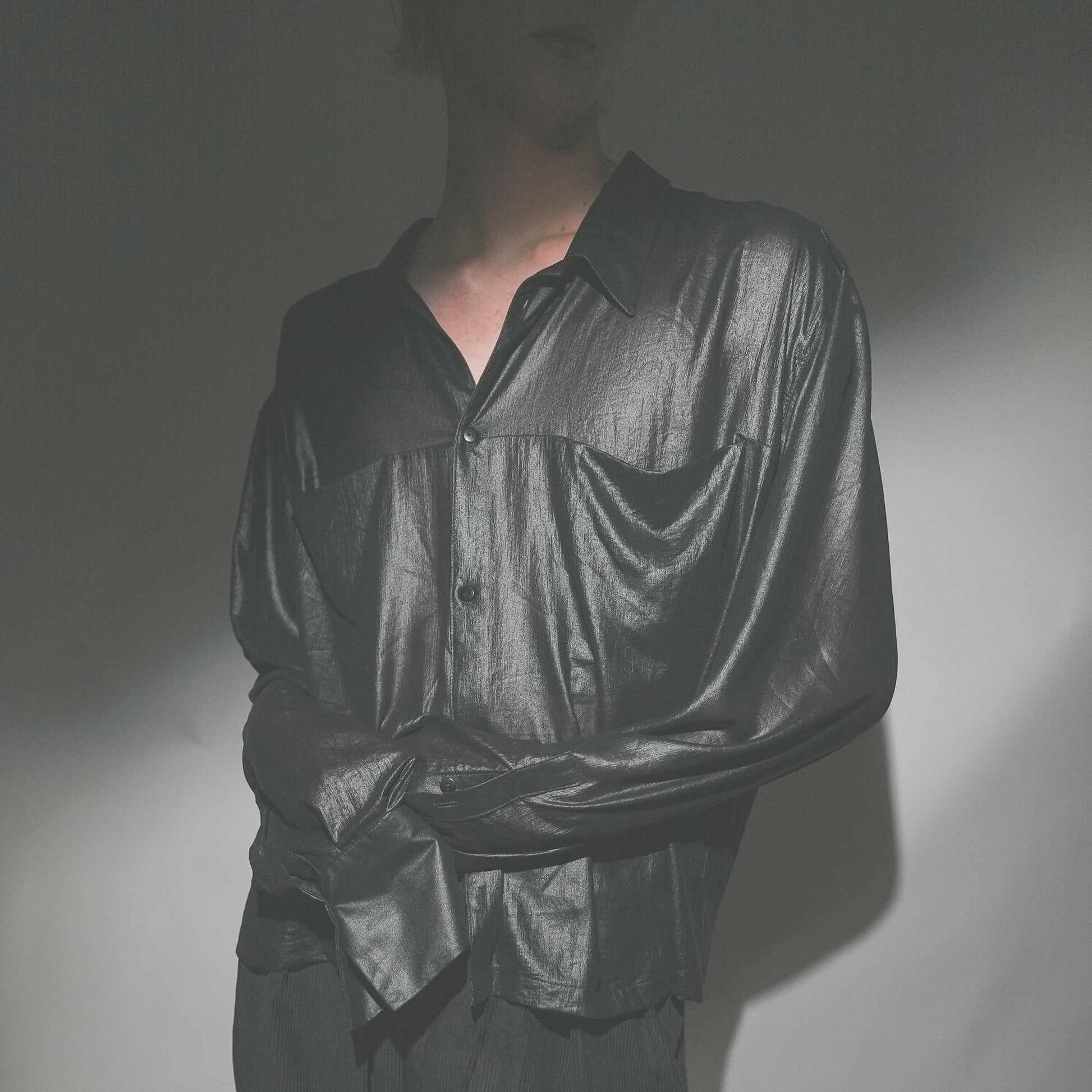 Close-up shot of the Marq Shirt in Liquid Black detailing the drape, inseam pocket detail, and button closure