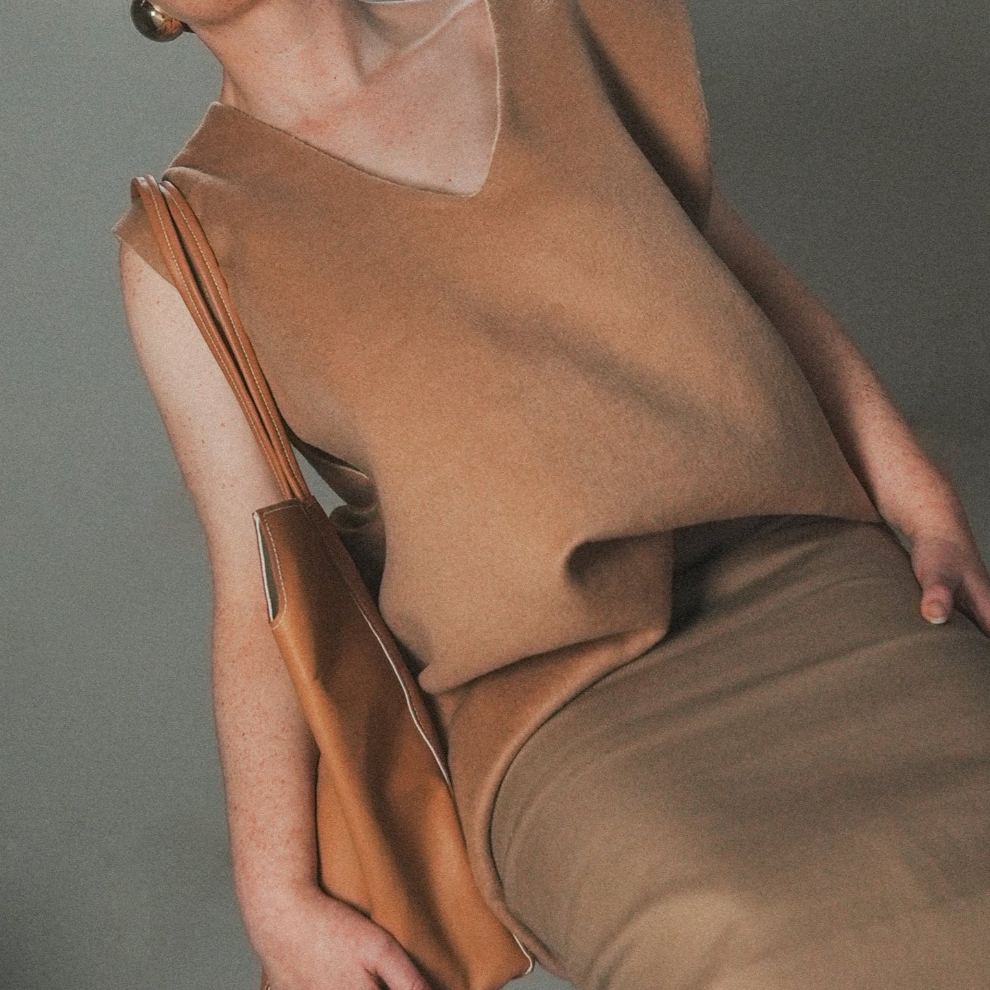 Model wearing the Tan side of the reversible oversized wool vest with soft brushed texture and hand finishing, styled over casual outfit.