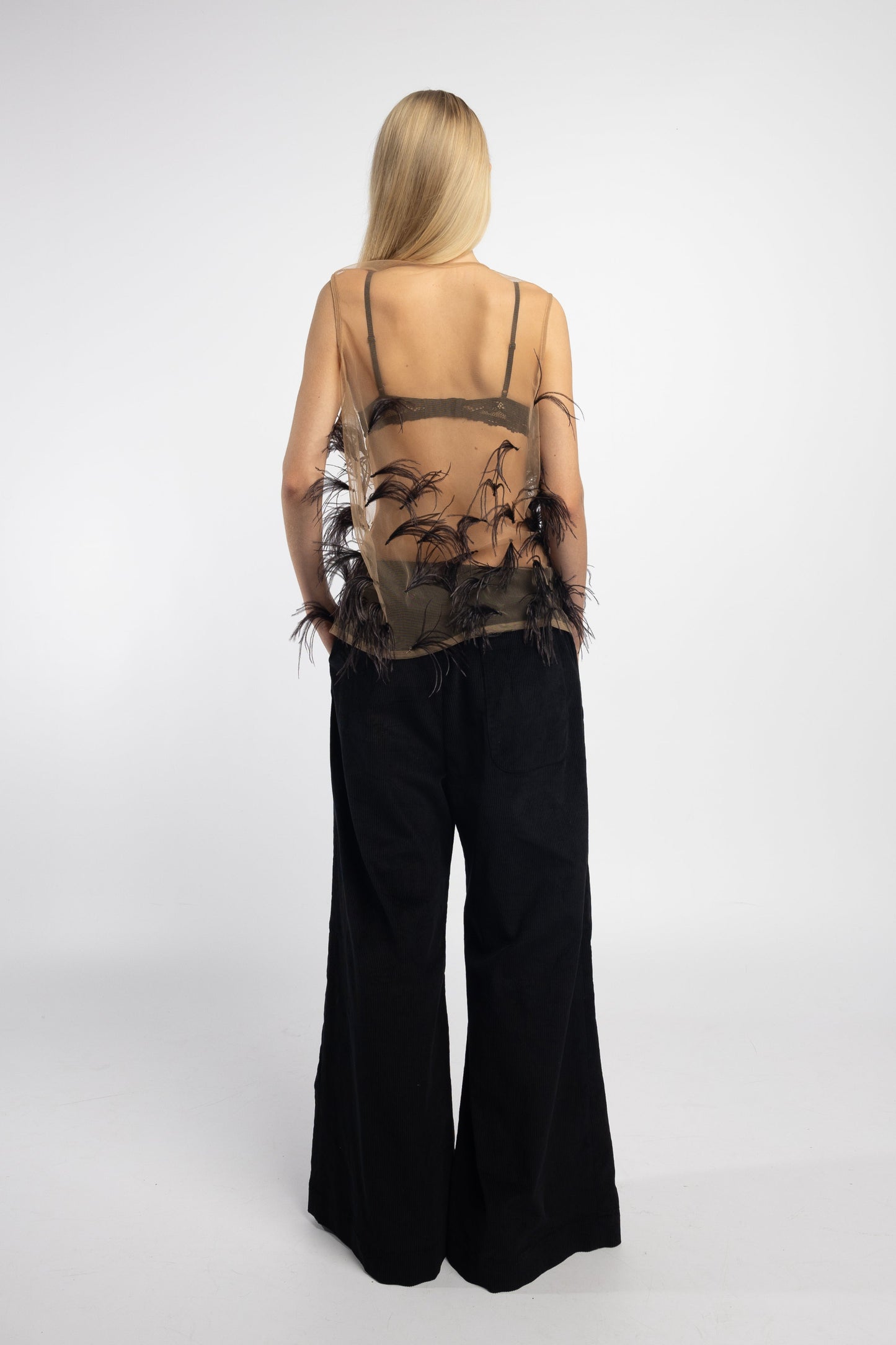 Close-up of hand-stitched ostrich feathers on nude mesh blouse back