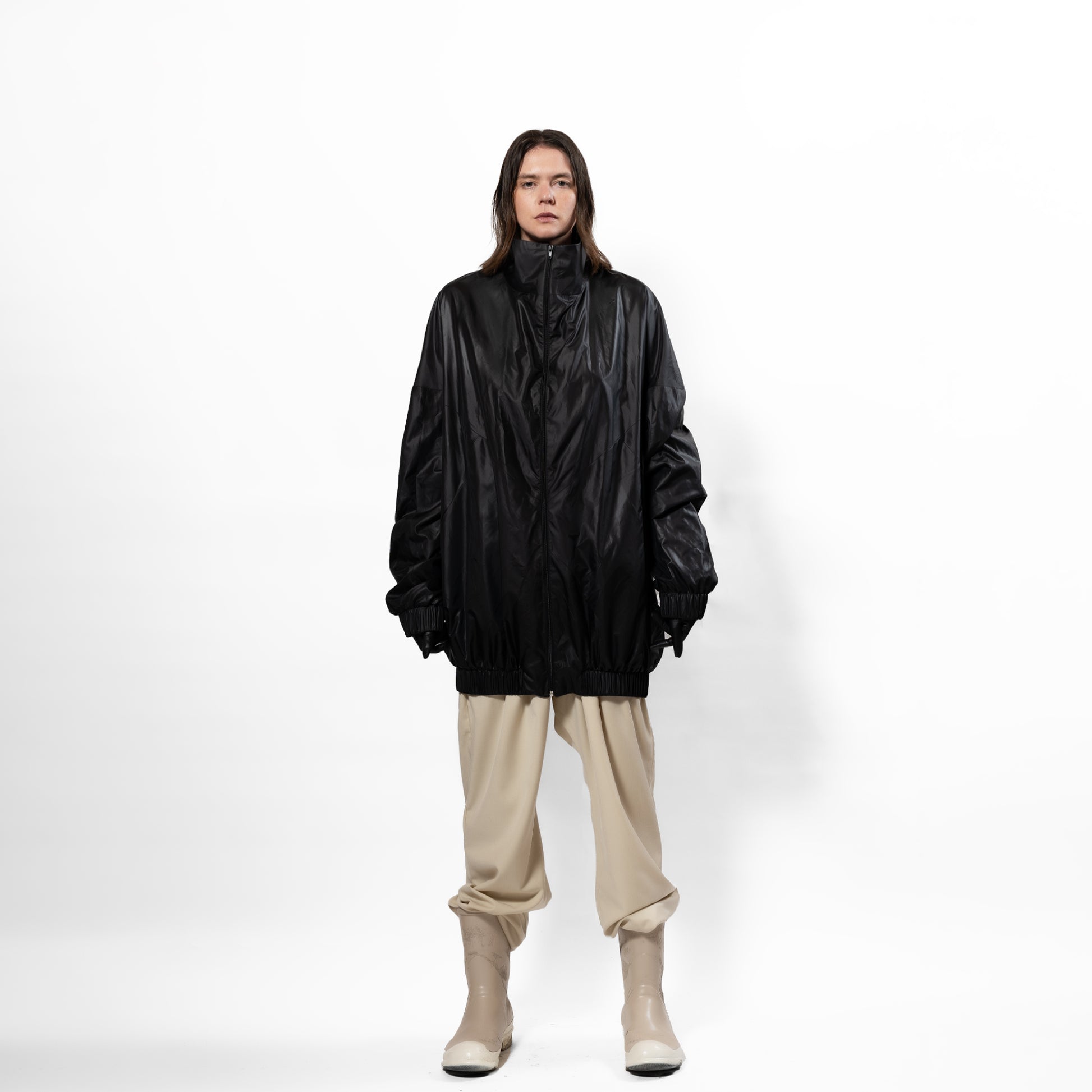 Black 90's inspired windbreaker Jacket with slight Sheen. Front zip, elasticated bottom hem and cuff. long front zip. one size fits all. Front full view.
