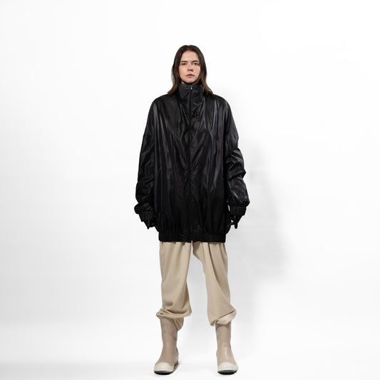 Black 90's inspired windbreaker Jacket with slight Sheen. Front zip, elasticated bottom hem and cuff. long front zip. one size fits all. Front full view.