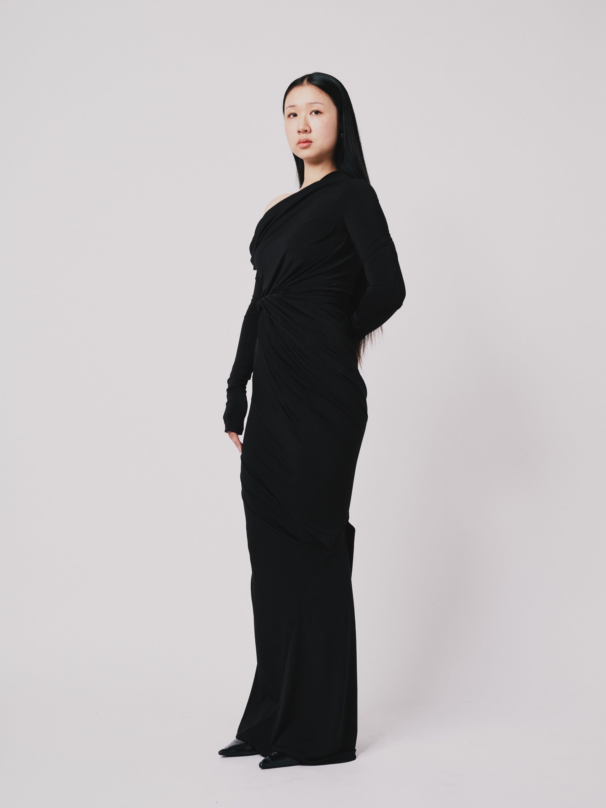 Woman wearing a black marq twist dress against a white background