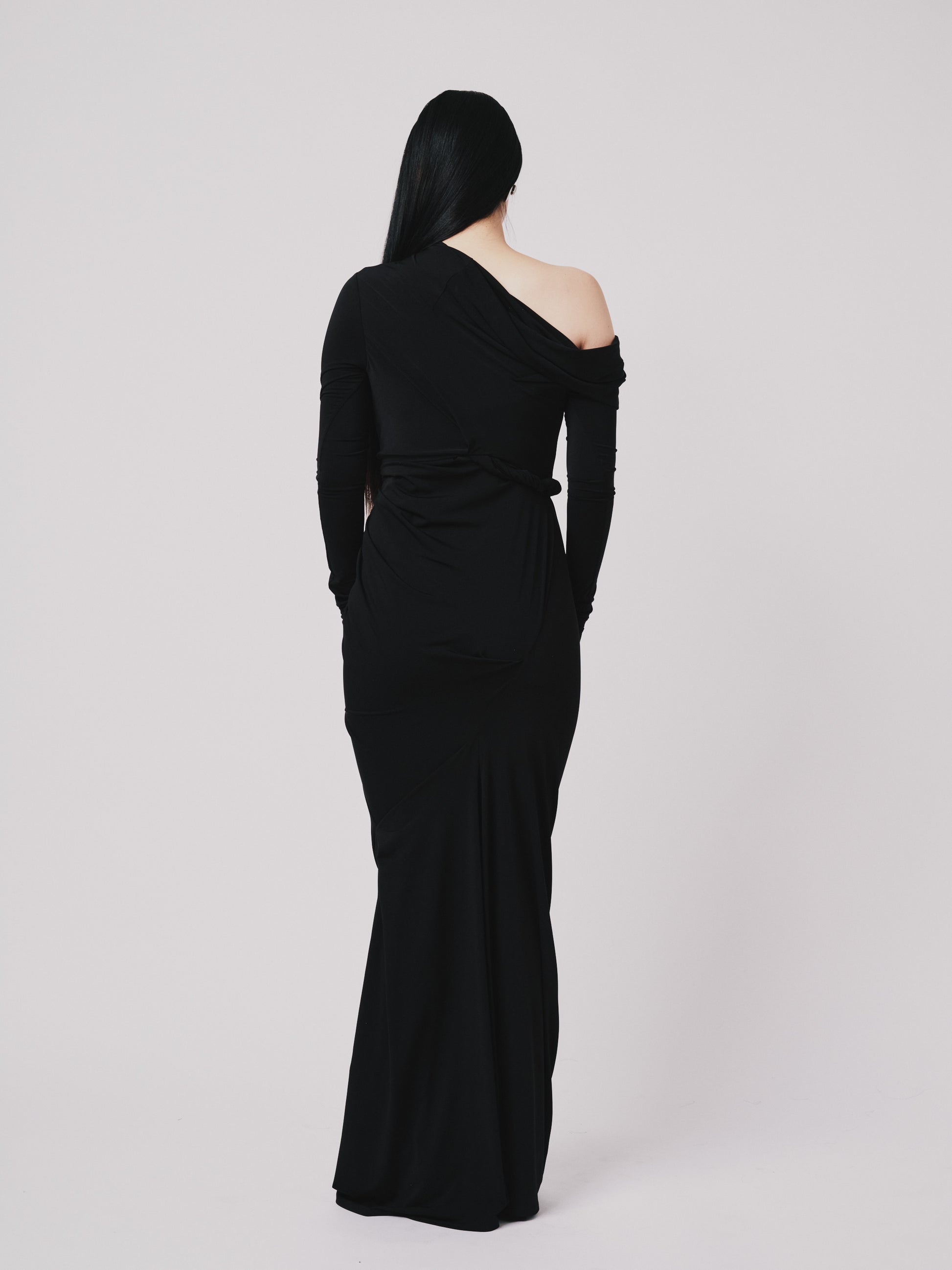 Black one-shoulder evening gown on a white background back view