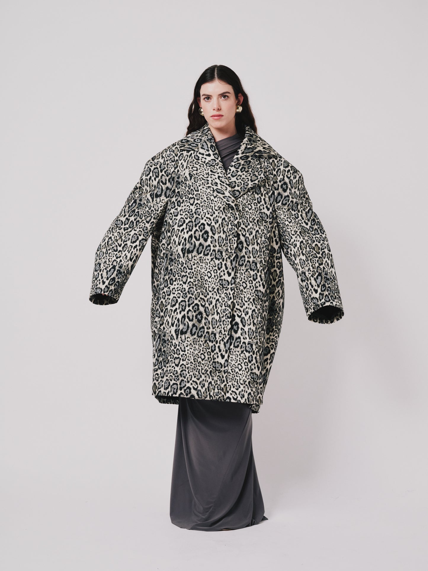 Person wearing a leopard print coat on a plain background front view 