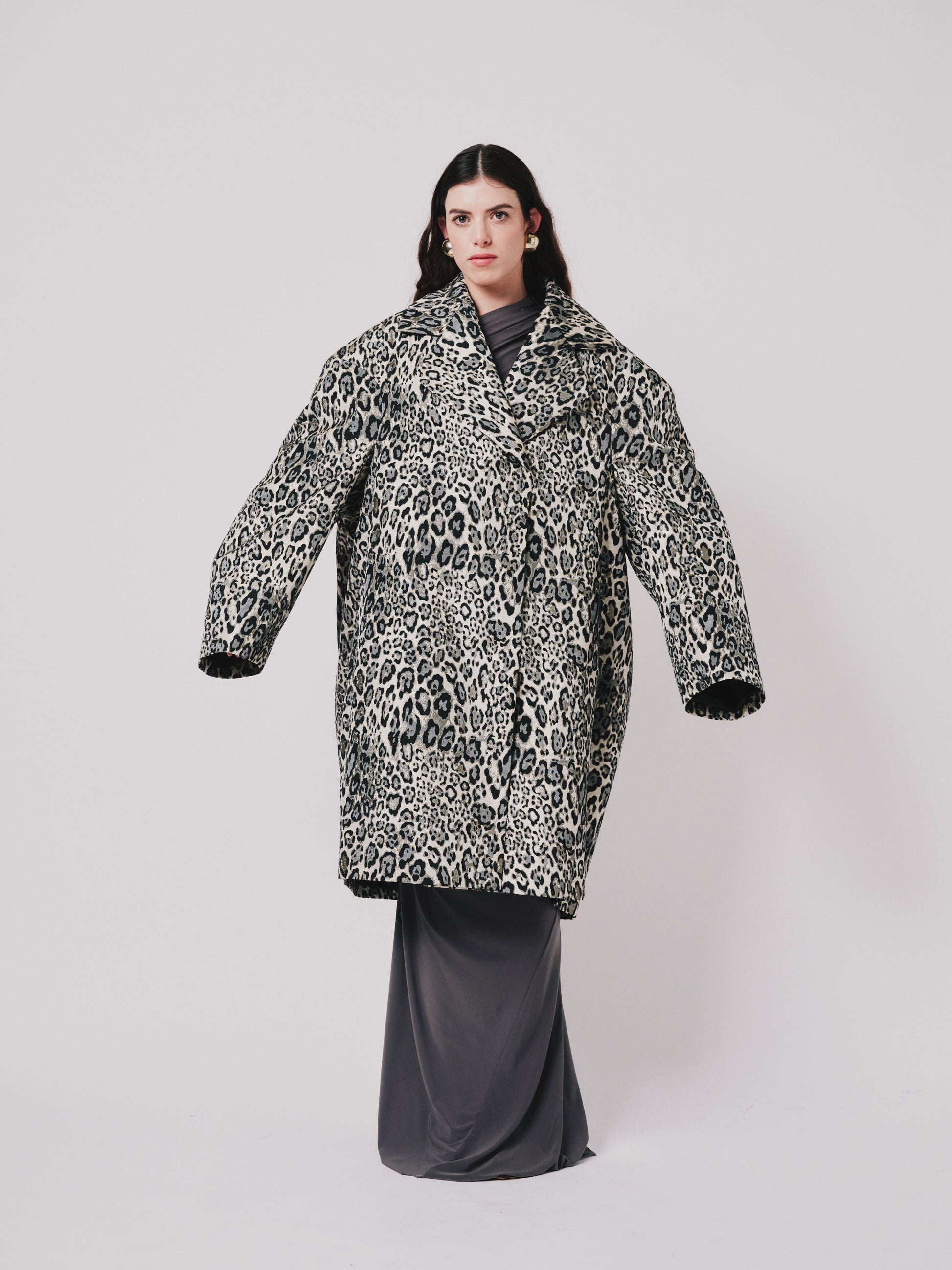 Person wearing a leopard print coat on a plain background front view 