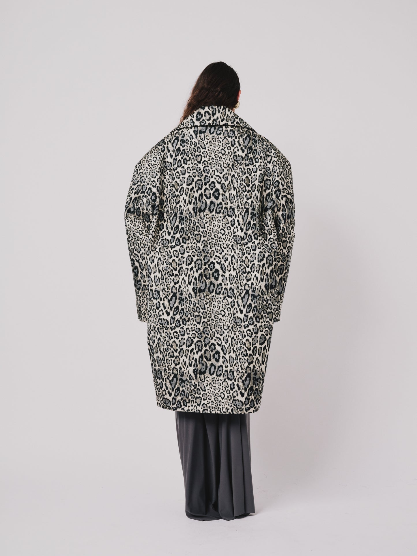 Person wearing a leopard print coat on a white background back view 