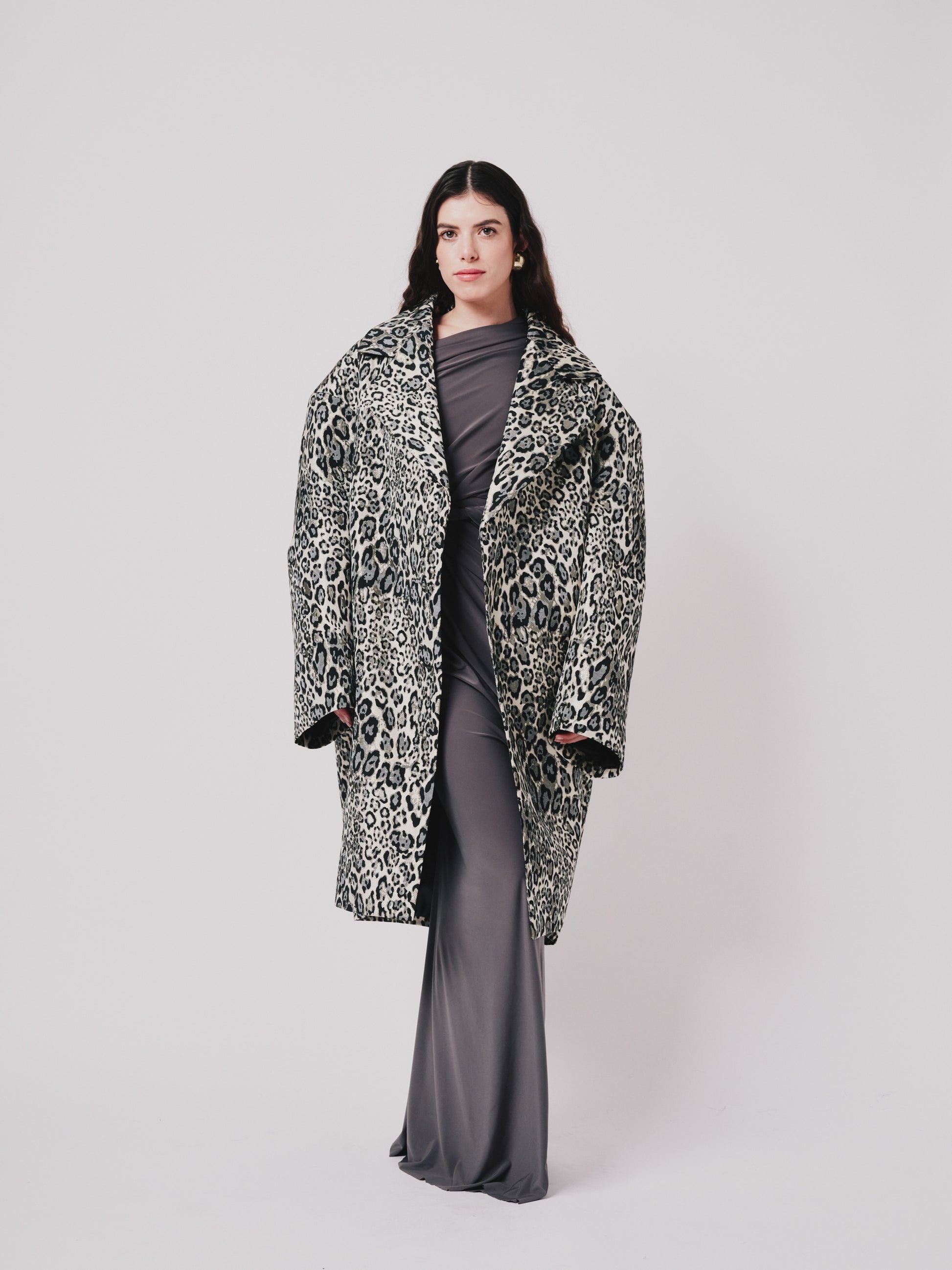 Woman wearing a leopard print coat on a white background front pose 
