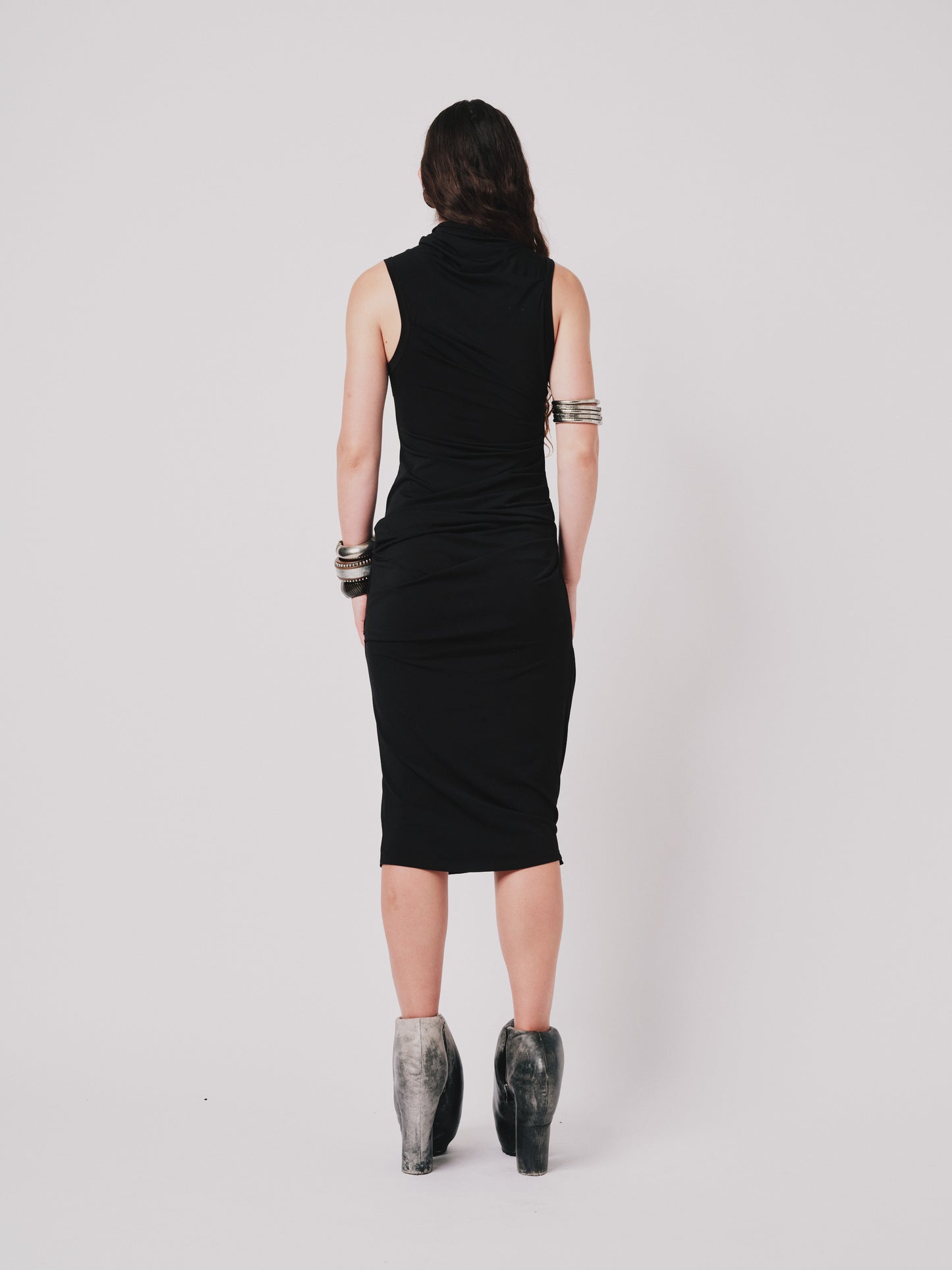 Person wearing a black Paloma dress sleeveless dress on a white background