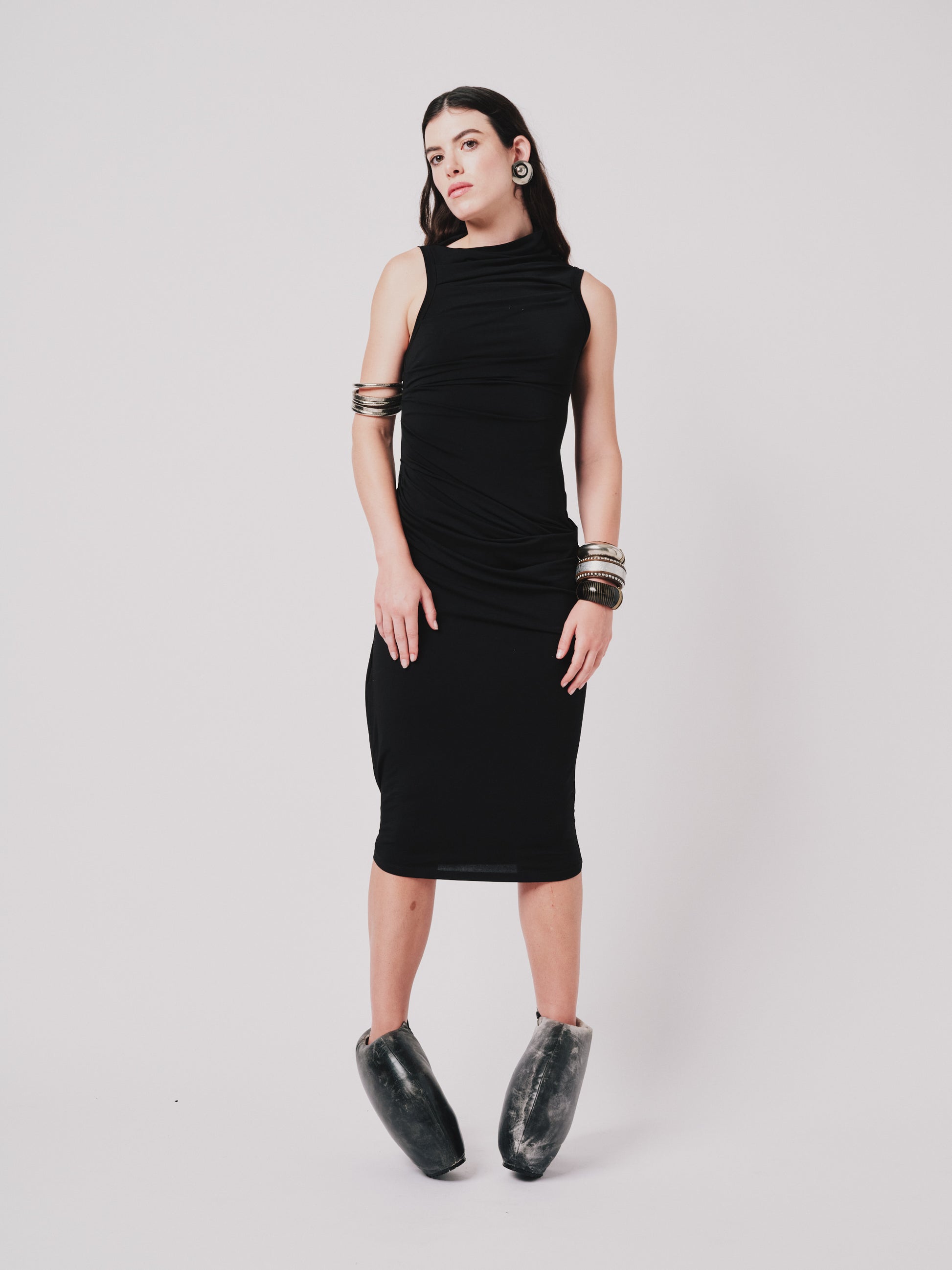 Woman wearing a black Paloma sleeveless dress with a plain background