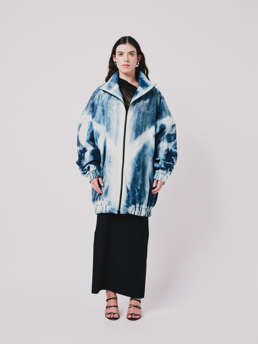 Person wearing a blue and white distressed youhan jacket on a plain background. Front view