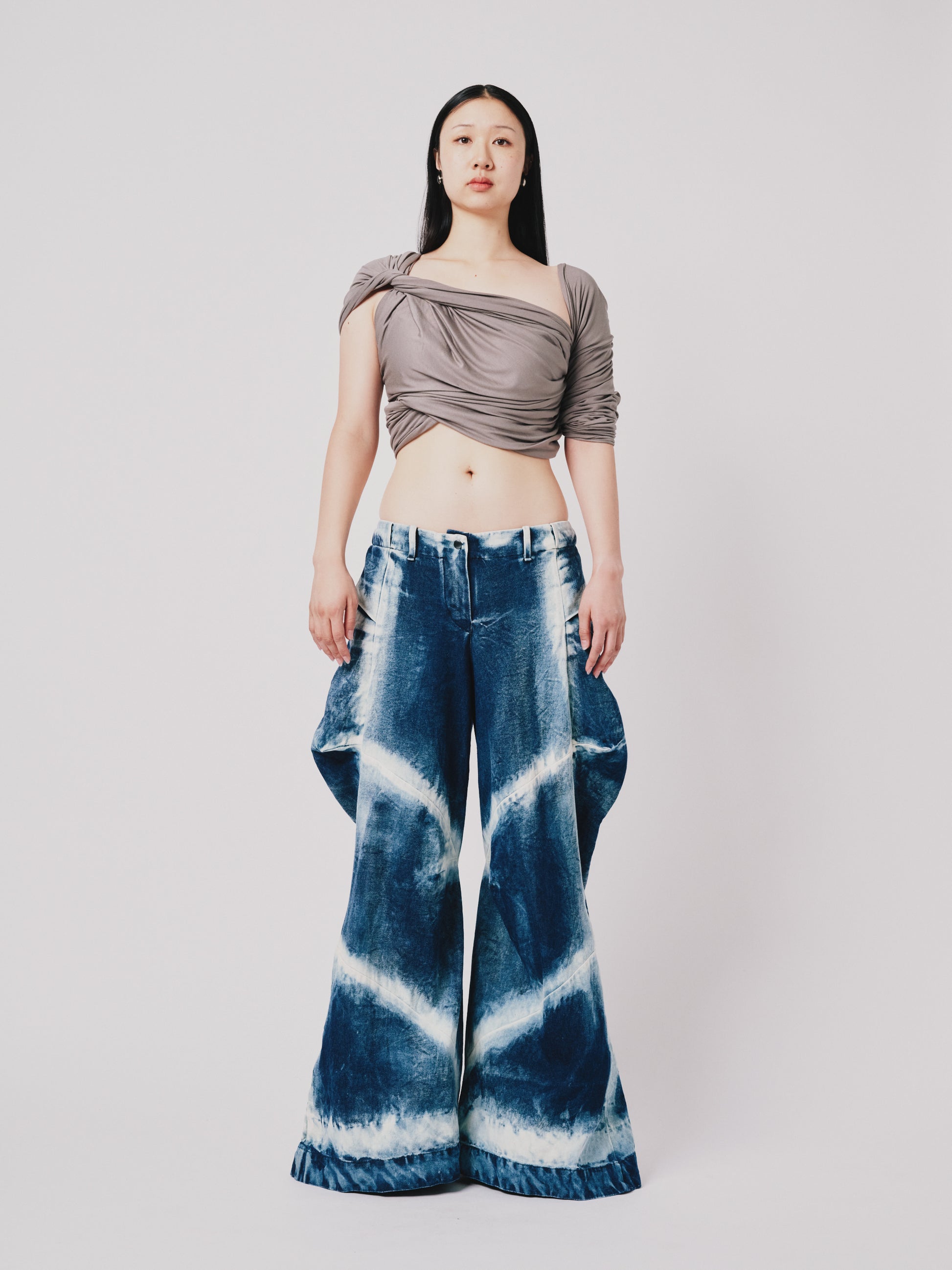 Person wearing distressed cargo pant in blue denim on white background. Front View