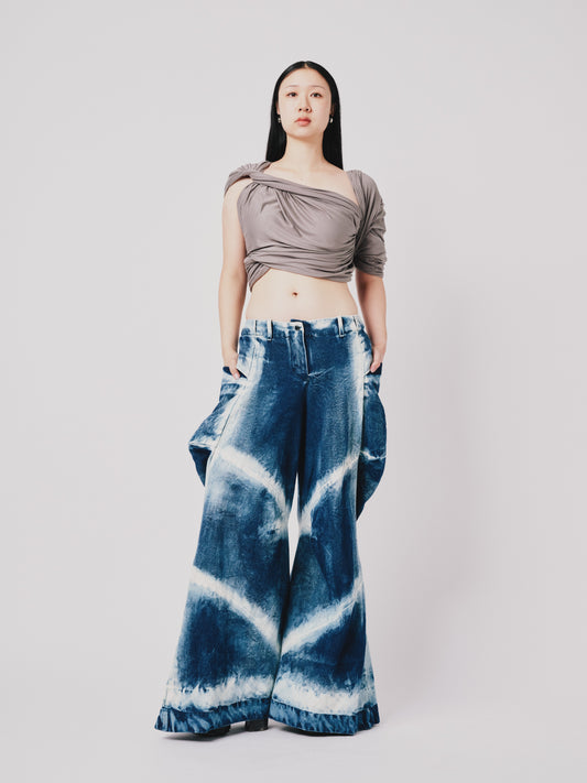 Person wearing distressed cargo pant in blue denim on white background. Front view