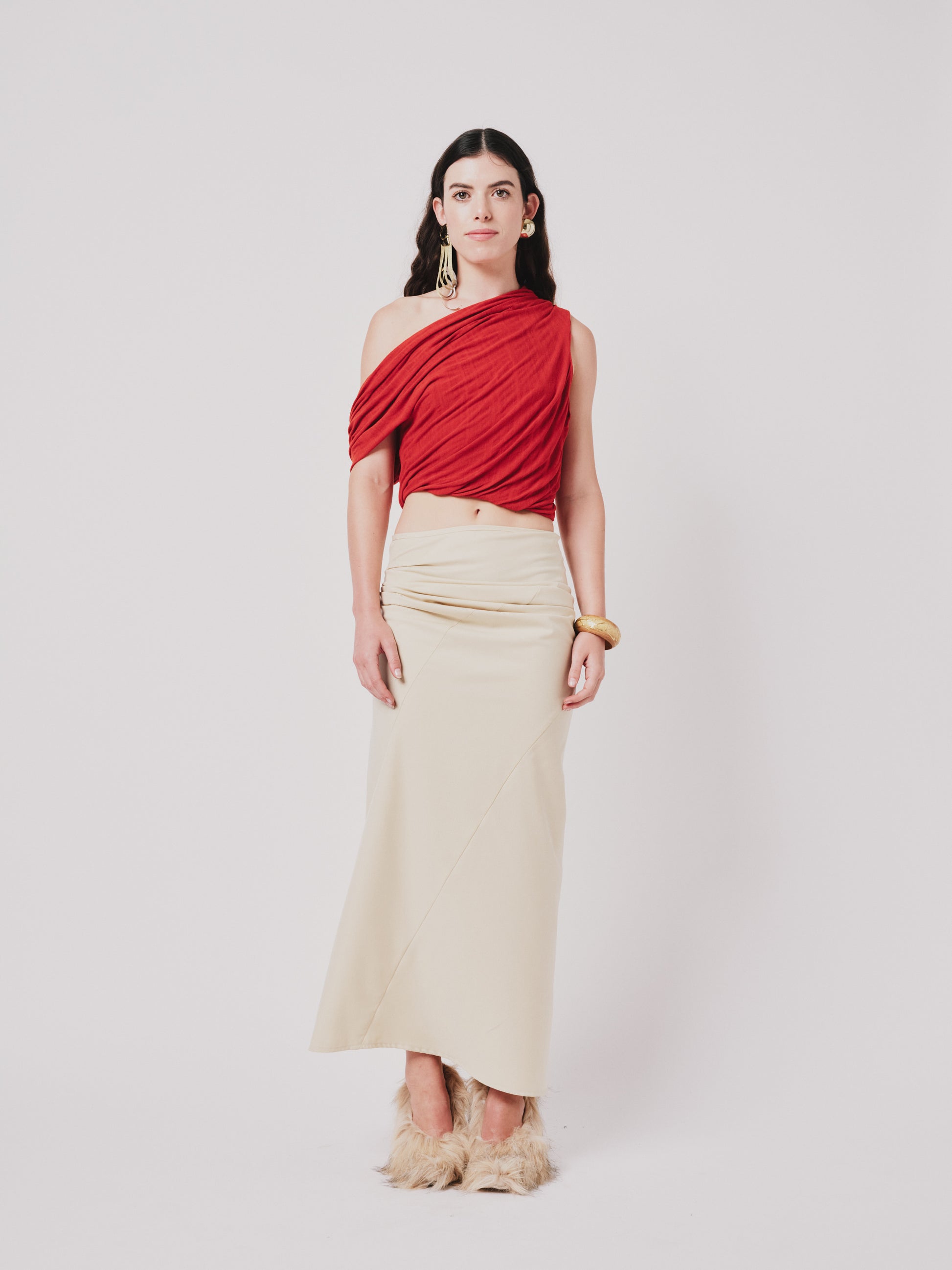 Woman wearing a top and structured draped skirt in pear sorbet.  Front view