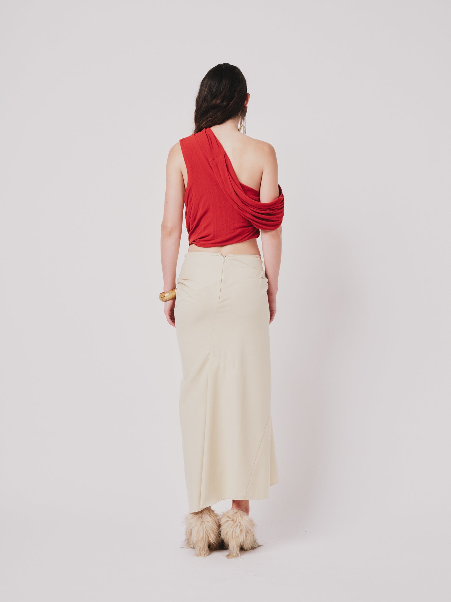 Woman wearing a top and structured draped skirt in pear sorbet. Back view