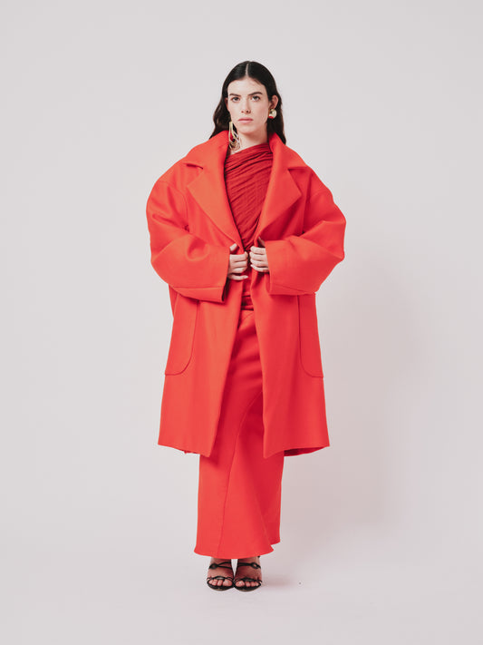 Woman wearing a Hoffman coat in Orange on white background. Front view