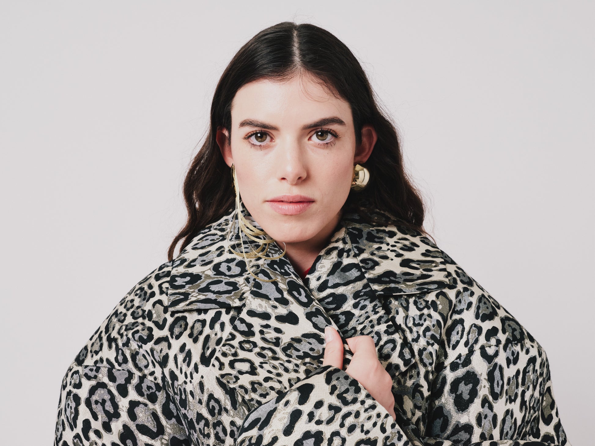 Woman wearing a leopard print coat against a plain background collar detail