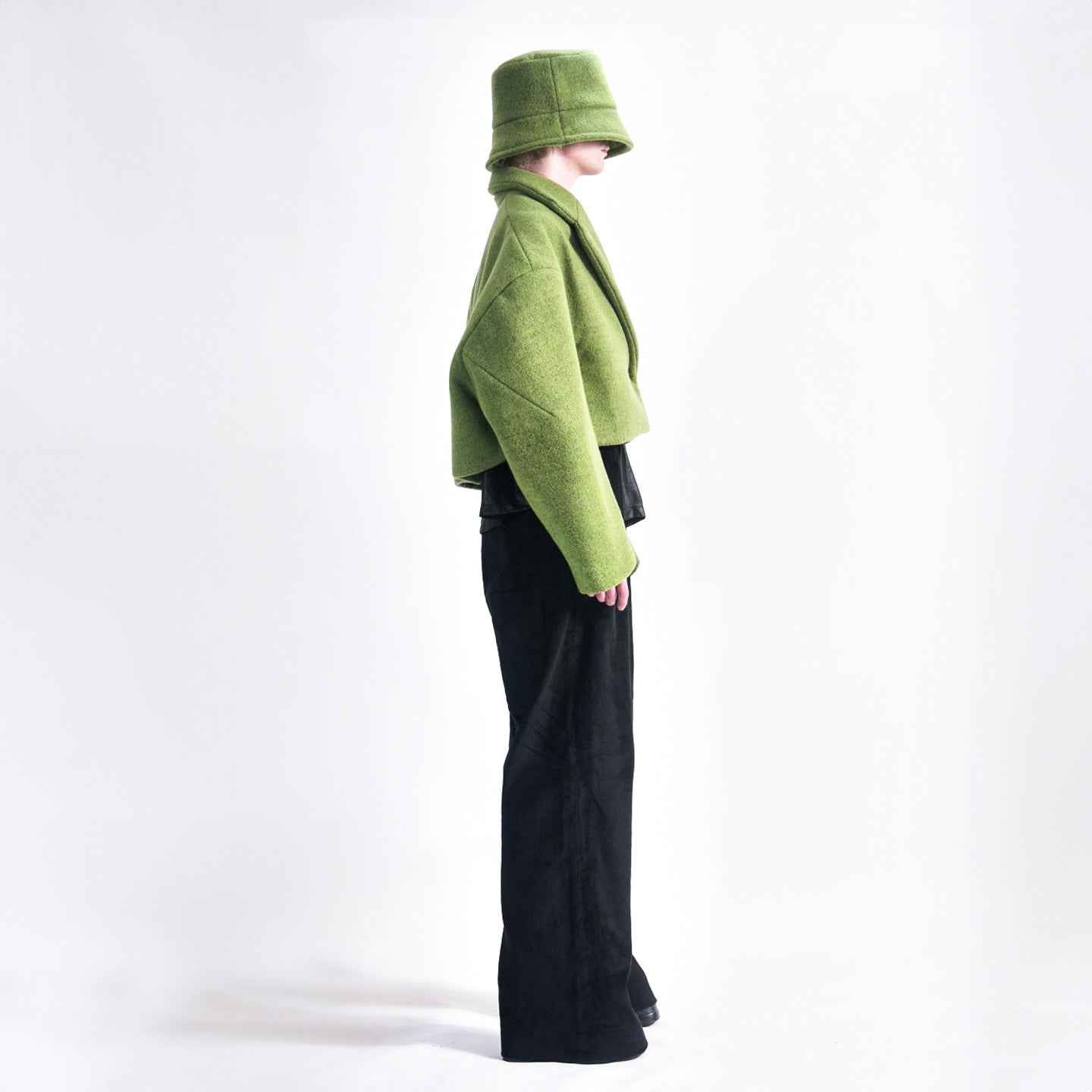 Side view of the Hoffman Hybrid Puffer jacket in colour Moss highlighting the dart sleeve detail and press stud closure