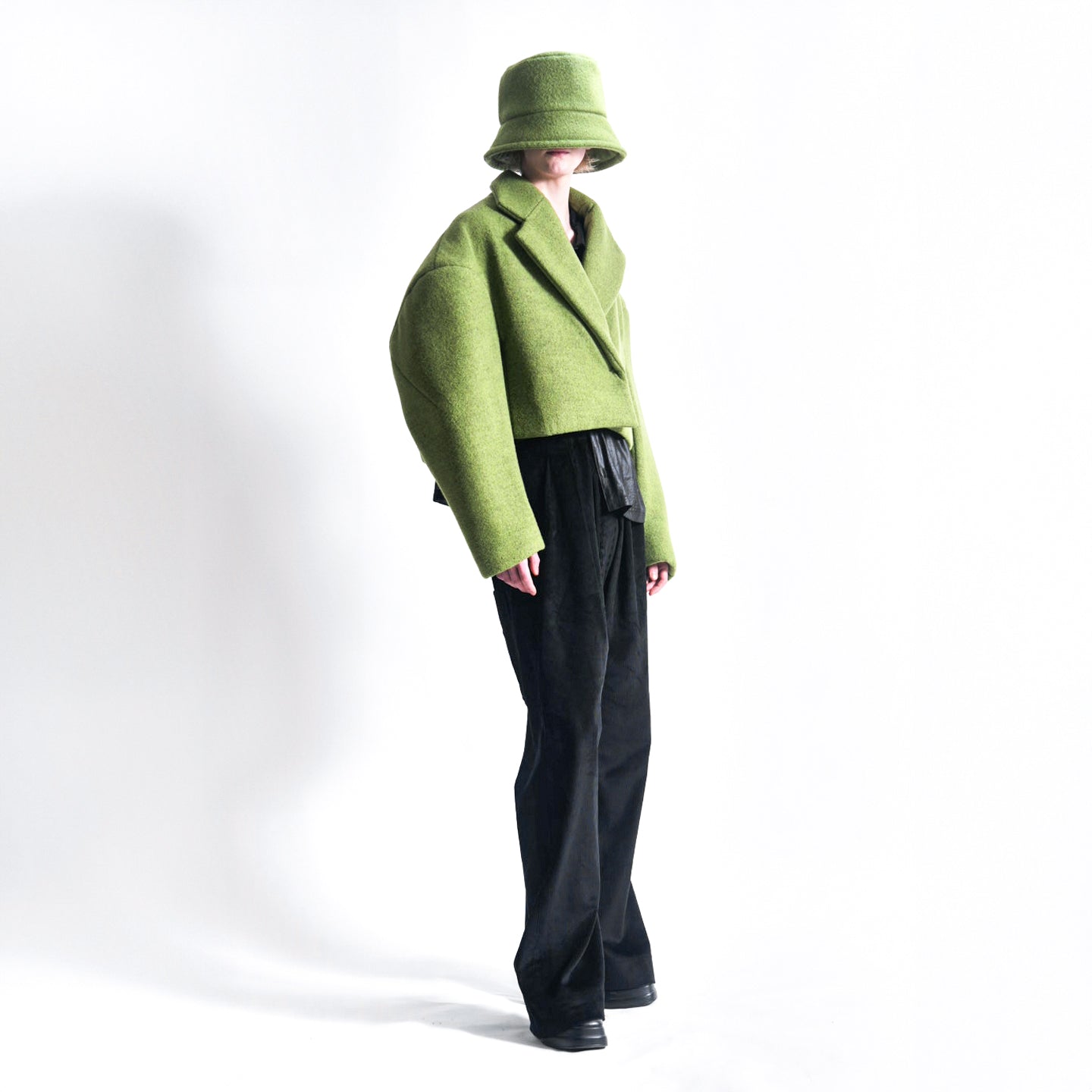 Side view of the Hoffman Hybrid Puffer jacket in colour Moss highlighting the dart sleeve detail and press stud closure.2