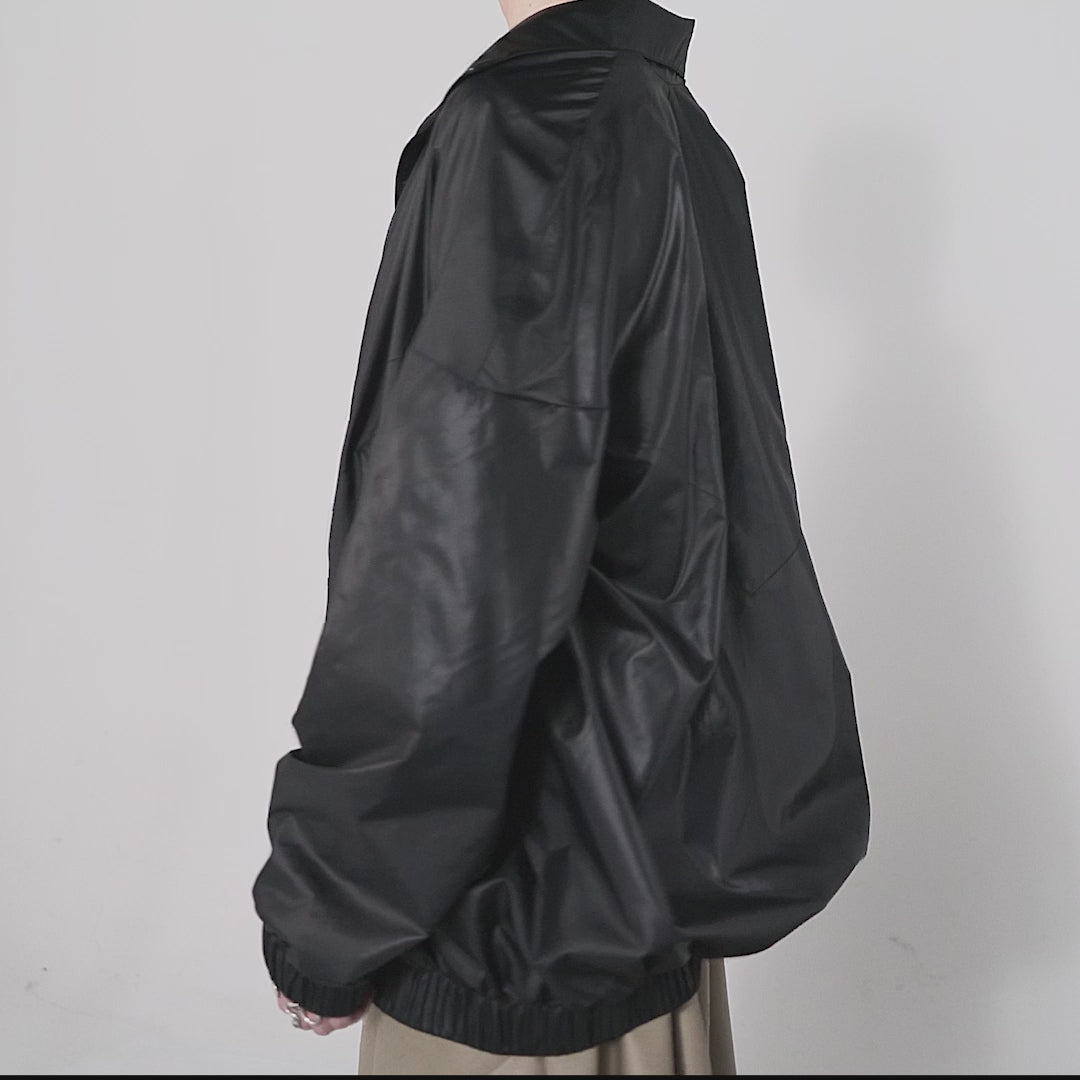 Black 90's inspired windbreaker Jacket with slight Sheen. Front zip, elasticated bottom hem and cuff. long front zip. one size fits all. 360 view Video.
