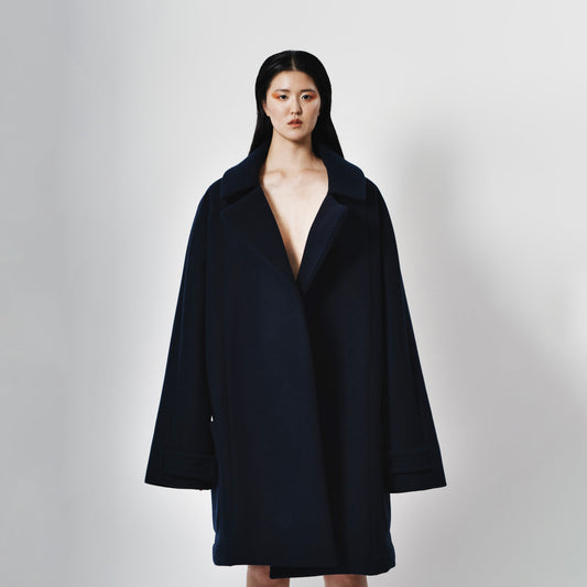 Oversize Navy Blue Neoprene Coat with oversize front pockets. Oversize Fit. Front view.